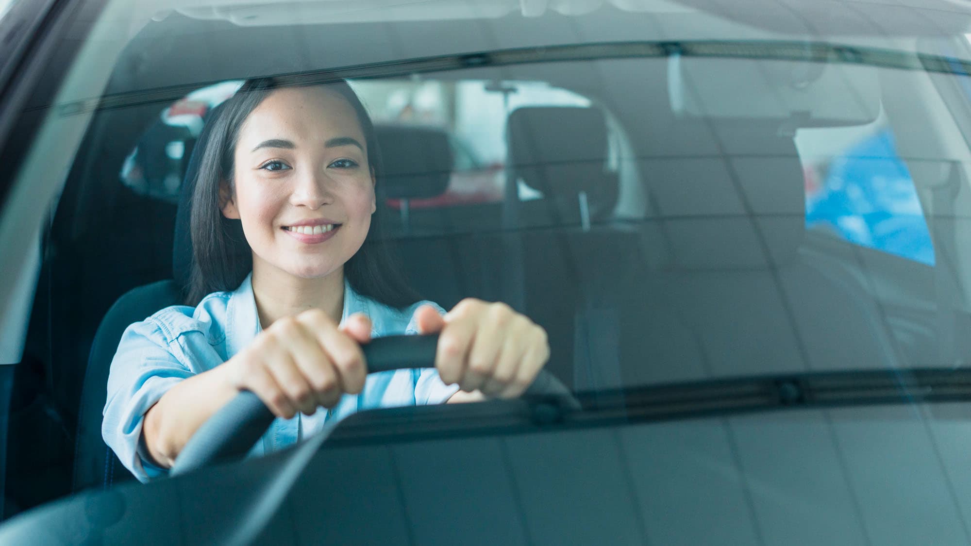 Woman driving car and smiling